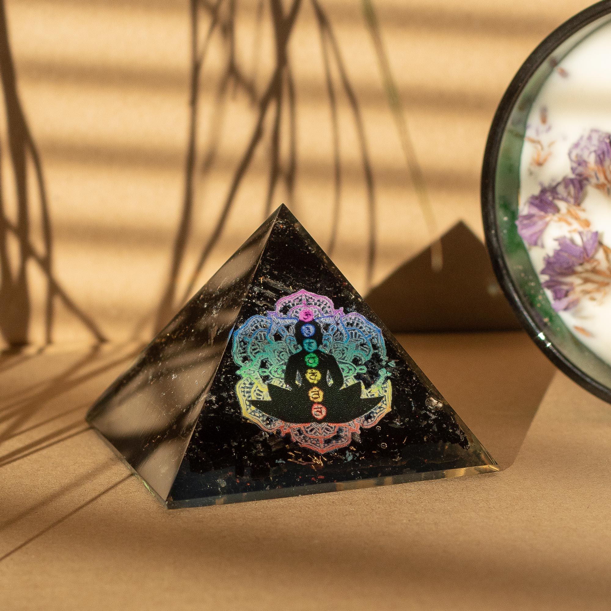 Liten orgonitpyramid av svart turmalin 5,5x4,5 cm med buddhamotiv och chakran